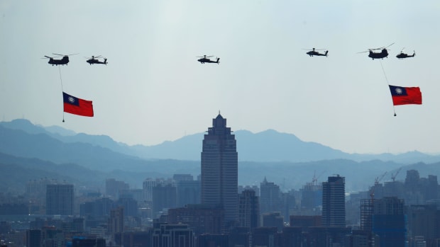 Military helicopters carrying Taiwan flags conduct a rehearsal ahead of National Day celebrations near Taipei.