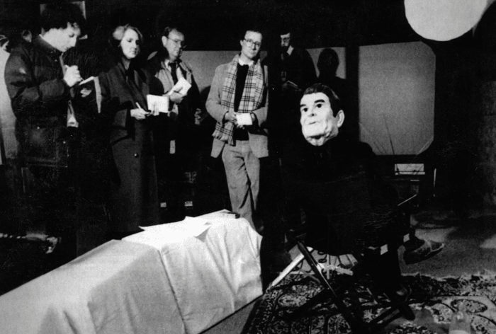 Members of the news media take part in an interview with R. Gardner "Tobe" Terrell, a member of the Finders communal group, in a warehouse owned by the group. Terrell wore a rubber mask of President Reagan on the back of his head to prevent identification.