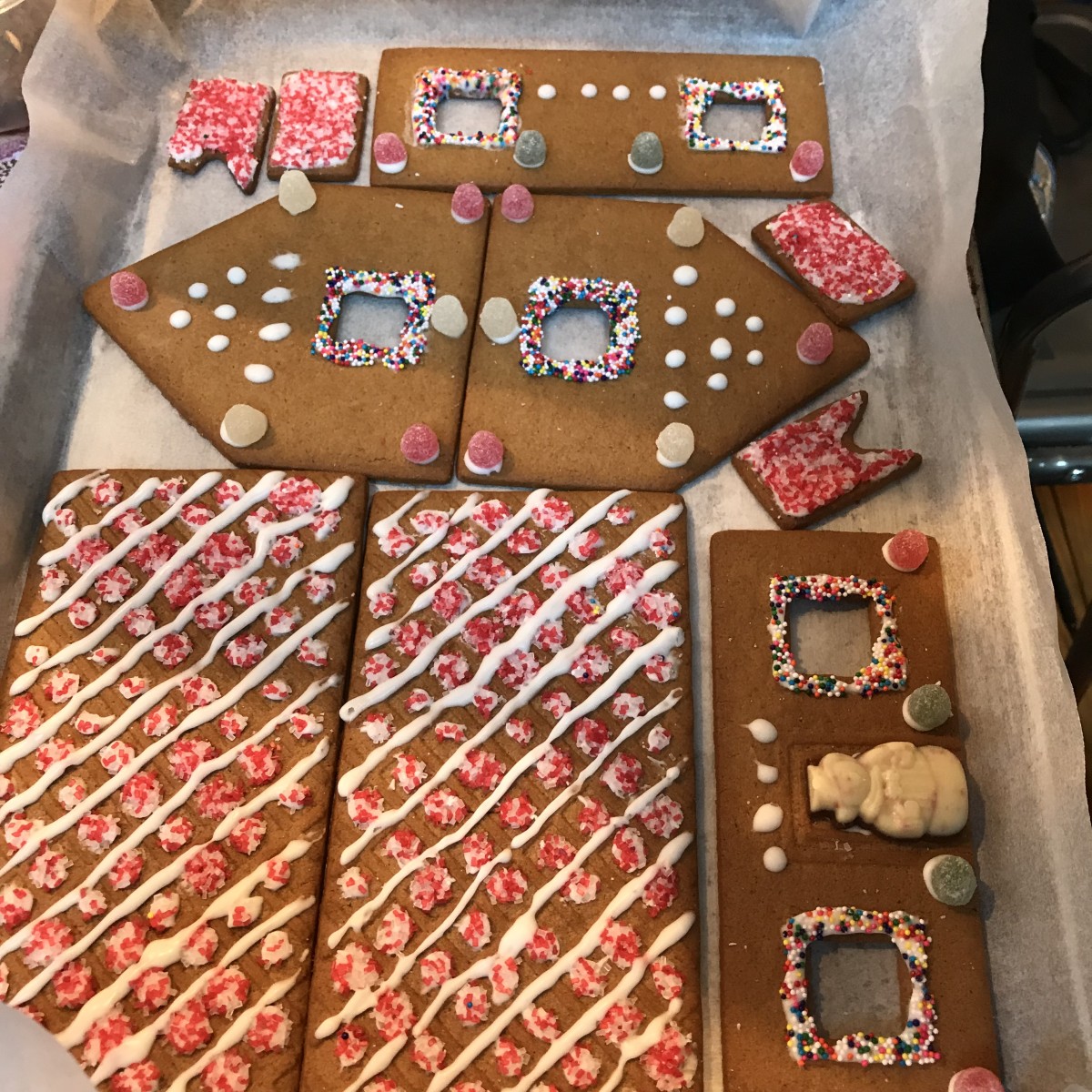 A ginger bread house, decorated and waiting for assembly